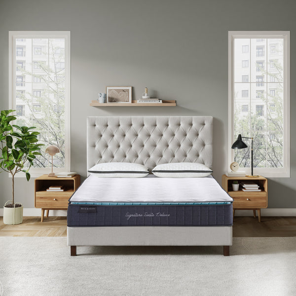 Bedroom with a tufted headboard and mattress in a well-lit room.