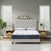 Bedroom with a tufted headboard and mattress in a well-lit room.
