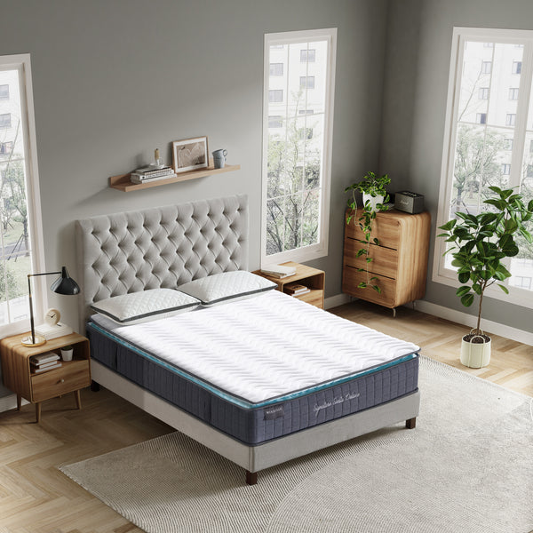 Bedroom with a tufted headboard and a mattress on a bed